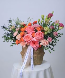 Rosas de jardín en cesta de mimbre