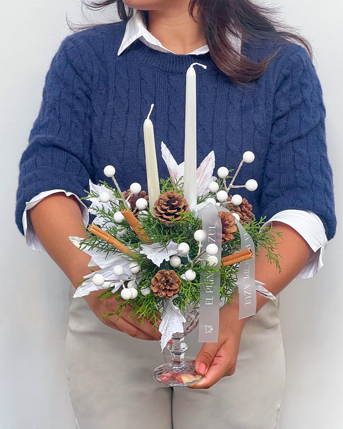 CHRISTMAS-CUP-00-CHRISTMAS-ARREGLOS-EPA-2025 HOLIDAY CUP es una copa de deseo de fiestas que celebra la Navidad con pino fresco, canela y detalles navideños blancos, evocando gratitud, armonía y belleza en cada rincón. Un gesto encantador, confeccionado con alma, para acompañar sus deseos más sinceros en esta temporada.