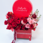 HAPPY AMORE combina flores premium, rosas rojas y un globo personalizado en una elegante caja de madera, creando un gesto alegre y sofisticado que celebra el amor con emoción, estilo y el sello inconfundible de El Príncipe Azul.