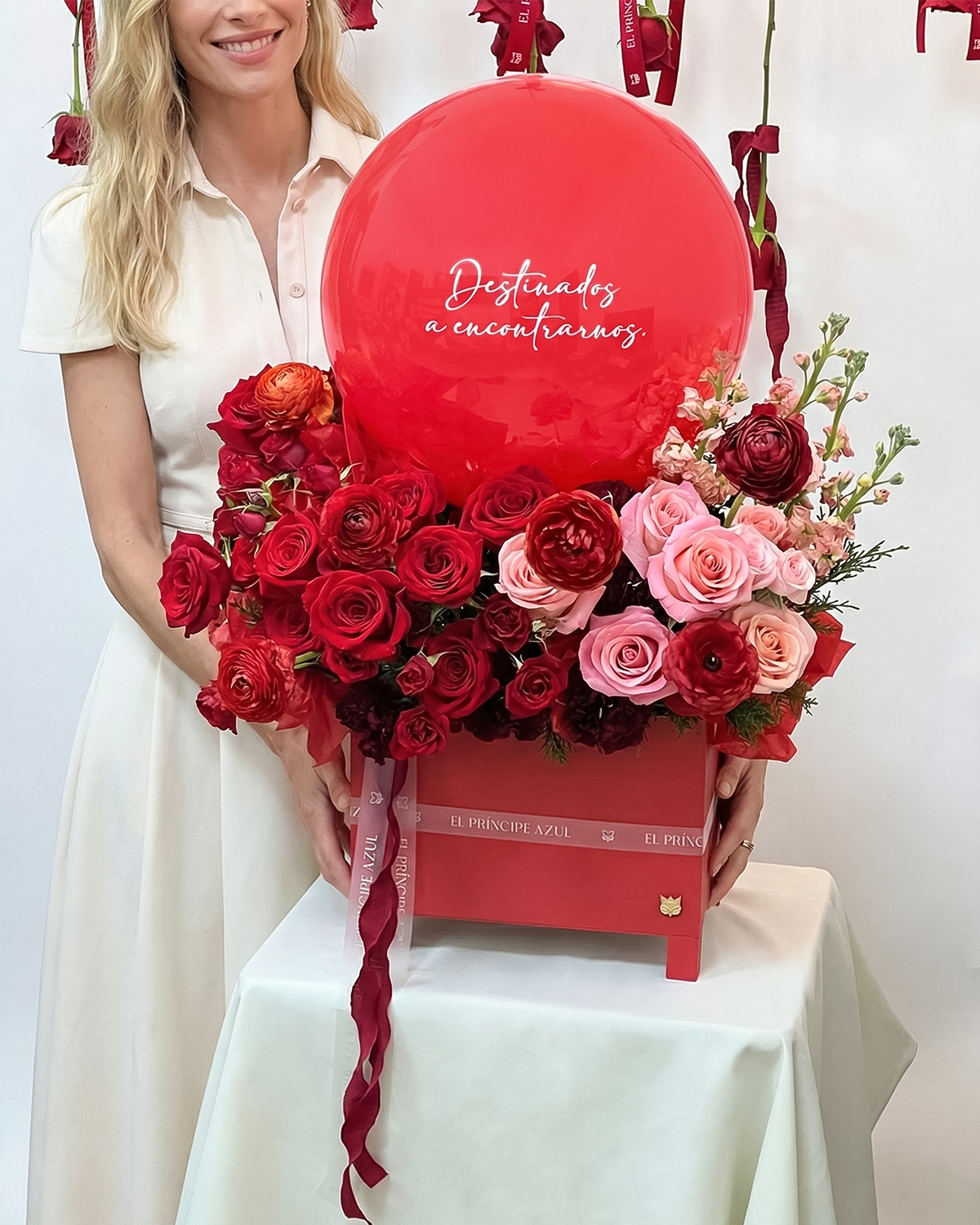 HAPPY AMORE combina flores premium, rosas rojas y un globo personalizado en una elegante caja de madera, creando un gesto alegre y sofisticado que celebra el amor con emoción, estilo y el sello inconfundible de El Príncipe Azul.